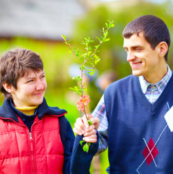 two persons holding a branch